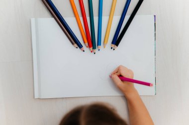 Küçük kız masaya tebrik kartı çiziyor. Babalar Günü konsepti.