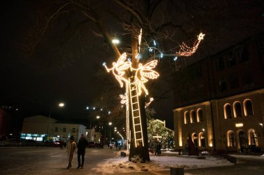 Kyiv, Ukrayna 1 Aralık 2021 Noel Aydınlatma. Işık festivali. Yılbaşı bayramında şehir caddesinde dekore edilmiş. Meleklerin figürleri, gökyüzüne çıkan merdivenler, ağaçtan yapılmış çelenkler..