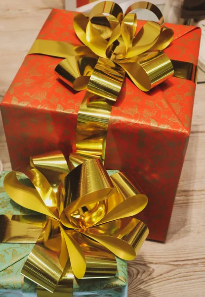 ギフトボックスのトップビュー 大きな金の弓垂直背景で飾られたカラフルな赤と青の紙に包まれたプレゼント コンセプトお祝い 誕生日 新年2023 クリスマス 2月14日 — ストック写真
