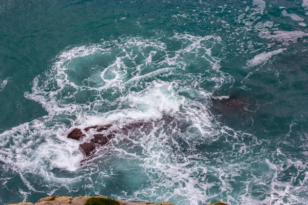 一个有漏斗的汹涌大海 从悬崖上看到蓝色的水涡 循环水顶部视图 岩石从水下可见 岩石的大西洋海岸线 水生背景 — 图库照片