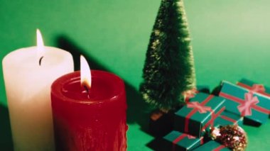 Dekoratif çam ağacının olduğu yeşil Noel retro videosu, kış tatilinde hediye kutuları. Kırmızı beyaz yanan mumlar mum ışığı. Yeni yılın kutlu olsun 2023. Kutlama konsepti, satışlar