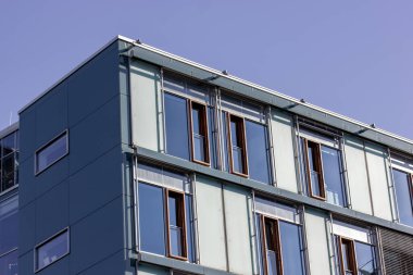 Mavi evin dış görünüşü ve pencereleri. Modern bir konut binasının köşesi, villa, otel, kulübe. Dış görünüşün mimari ayrıntıları, yapı. Aynalı pencereler. İnşaat, konut.