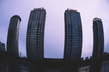 Kyiv, Ukrayna - 8 Ocak 2022: Dramatik mor gökyüzüne karşı cam cepheli modern çok katlı apartman binaları. Şehir manzarası şehir mimarisi. Finans Bölgesi. 