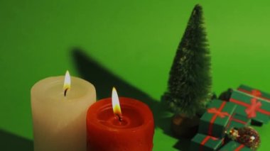 Dekoratif çam ağacının olduğu yeşil Noel retro videosu, kış tatilinde hediye kutuları. Kırmızı beyaz yanan mumlar mum ışığı. Yeni yılın kutlu olsun 2023. Kutlama konsepti, satışlar