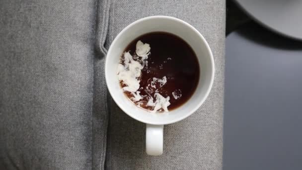 一大杯黑咖啡 加奶油在热饮料中溶解 清晨咖啡与牛奶在灰色的沙发上 在现代家庭内部的顶视图 慢动作倒奶油 牛奶倒 — 图库视频影像