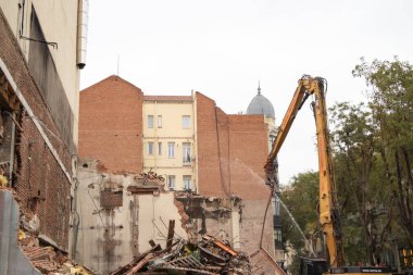Madrid, İspanya. 24 Kasım 2022 'de şehrin tarihi bölgesinde eski bir tuğla bina yıkıldı. Sürüngen kazıcısı şehir alanında. Eski model ev yıkımı. Yapı enkazı.