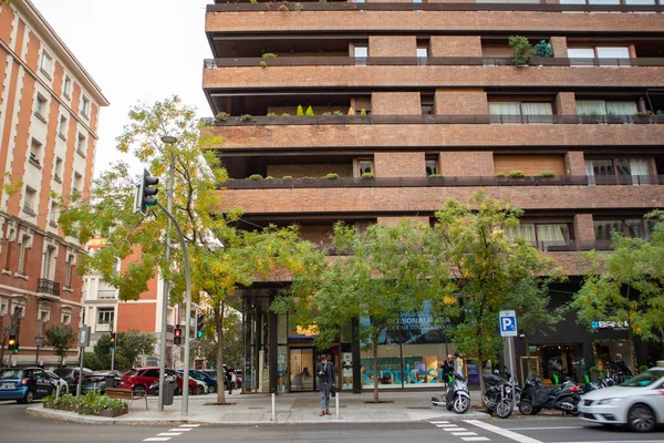 西班牙马德里 2022年11月24日 一座现代住宅和绿树的一角 一栋棕色的公寓楼 在市区有长廊 舒适的社区 出租车在路上行驶 交通拥挤 — 图库照片