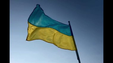 Ukrayna 'nın sarı-mavi bayrağı mavi gökyüzüne karşı rüzgarda dalgalanıyor. Rusya 'nın Ukrayna' ya karşı 2022 yılındaki savaşında Kyiv 'e verilen desteğin bir sembolü olarak. Sosyal sorun. 