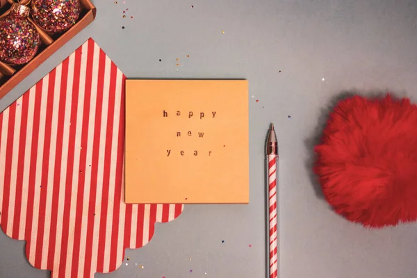 Vintage Christmas backdrop view overhead. Christmas decor 2023 Letter to Santa Claus, greeting card with text Happy New Year. Red white ballpoint pen, kraft paper template flatly on grey blue backdrop