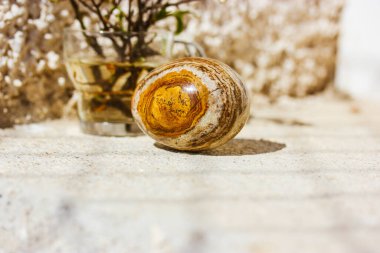 Paskalya yumurtası, bej arka planda doğal kahverengi sarı taş desenli. Bahar tatili dekoruyla bahar sakin bir hayat. Sinematik özgün Paskalya konsepti. Asgari duvar kağıdı.