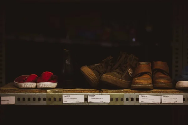 マドリード スペイン2022年5月1日古い靴を履いた棚 暗い背景のスニーカー 古いものの倉庫保管 必要としている人々のための人道援助ポイント 貧しい人々 — ストック写真