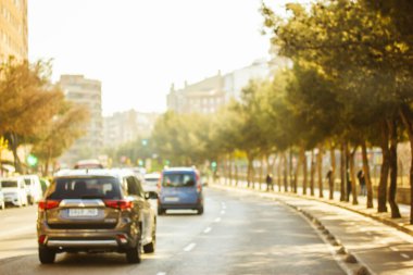 Güneşli bir günde şehir yolundaki trafiğin bulanık fotoğrafı. Altyapı, güzergah, büyük bir kasabada sıkışıklık. Şehir manzarası, megapolis yaşam konsepti. Taşımacılık. Yazın güneşli bir günde Avrupa 'ya seyahat. 