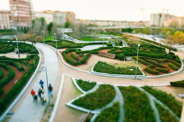 园林绿化的正规花园 城市公园的花坛 人们漫步在植物园顶部环抱曲折的小径上 绿色的灌木 城市里的草坪 选择性聚焦倾斜移位 — 图库照片