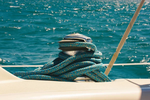Anchor winch for boats blue rope ropes on the ocean background. Sea travel in summer, adventure, voyage. Ships and yachts details. Pier for mooring. Vintage marina theme. Luxury summertime vacations.