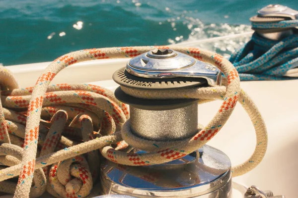 Anchor winch for boats blue rope ropes on the ocean background. Sea travel in summer, adventure, voyage. Ships and yachts details. Pier for mooring. Vintage marina theme. Luxury summertime vacations.
