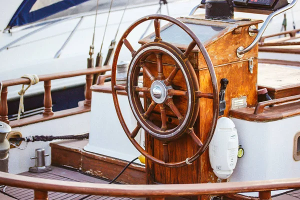 Wooden ship\'s rudder, boat wheel on an old vintage yacht. A device to control a movement of a watercraft. Travel by sea, ocean, cruise in summertime. Nautical vintage transport. Ferry on a seaside.