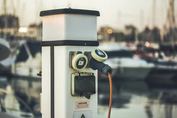 Charging station with electrical outlets for yachts in a harbor. Power socket bollard on pier. Marina theme. Charger cables outdoors. A station for boats in boat station Luxury lifestyle travel voyage