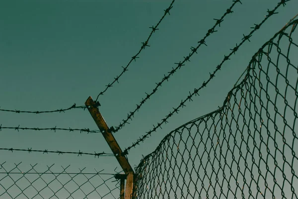 蓝天上有铁丝网 不自由 压制概念 私人地产 受金属栅栏保护的厂房区域 边境背景 — 图库照片