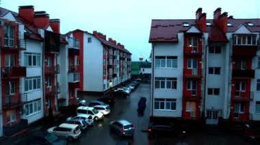Uzhgorod, Ukrayna, 1 Nisan 2022. Zaman atlamalı video, apartman bahçesi, araba trafiği olan evler. Gündüz geceye, akşam geceye dönüşür. Mahalle sakinleri. Karanlık gece karartması.
