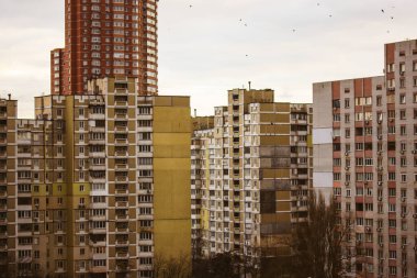 Kyiv, Ukrayna, 1 Ocak 2023 Başkentin yerleşim bölgesindeki yüksek katlı apartmanlarla yoğun kalkınma. Çirkin, eski ve modern apartman yüzleri. Sovyet sonrası çirkin mimari..