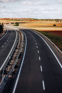 Madrid, İspanya 25 Nisan 2023 dört şeritli asfalt bir otoyol ufukta bir mesafeye gider. Güneşli bir günde seyahat etmek. İspanyol çayırlarından, gündüz çayırlarından geçeceğiz. Trafik yok.