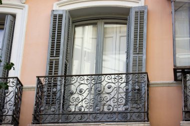 Klasik mimari tarzında mavi ahşap panjurlu klasik bir balkon. Eski usul, turuncu bina cephesi. İspanyol mimarisi dış görünüş. Güzel metal eskrim