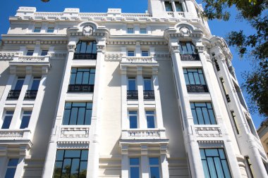 Madrid, Spain. May 1, 2022. The facade of a white high-rise residential building in the classical or neoclassical architectural style. Windows, balconies decorated with stucco. Architecture of Europe.