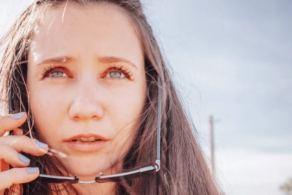 Beyaz Genç Kadın Güneş Gözlüğünü Çıkardı Endişeyle Gökyüzüne Bakıyor Mesajlaşmak — Stok fotoğraf