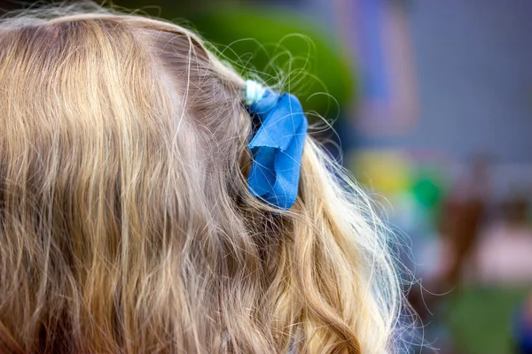 얼굴도 알아볼 수없는 곱슬머리에 파란색 리본을 머리에 아기의 머리는 뒤에서 — 스톡 사진