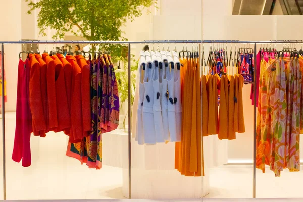 妇女服装店 彩色的红色 橙色的衬衫挂在商店橱窗里的衣架上 美容美发 时尚商务理念 女装衬衫 太阳衣 衣服架 购物及销售 — 图库照片