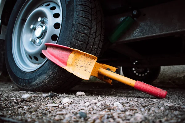 stock image A clamp is used to secure a front wheel of the automobile during transportation, repair. Orange and red wheel blocker. A locker for a car, automobiles. Unpaid parking. Booted vehicle on a city street.