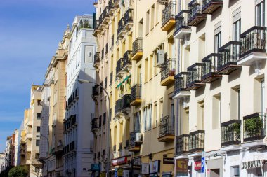 Madrid İspanya 5 Nisan 2023 Bir şehir caddesi güneşli bir günde perspektif alır. Mavi gökyüzüne karşı tarihi konutların cepheleri. Avrupa 'da neoklasik mimari. Seyahat kartpostalı. 