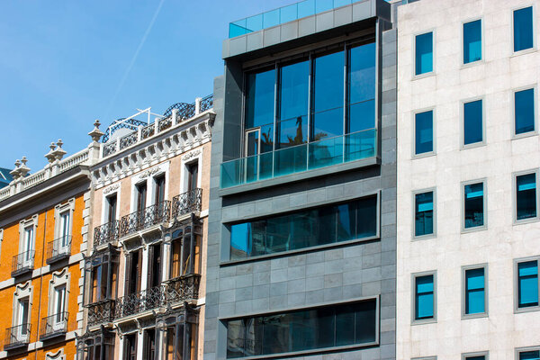 Madrid, Spain. May 1, 2022 Residential building facades in different architectural styles. A juxtaposition of modern and old historical architecture. Big city urban view. Office building glass facade.