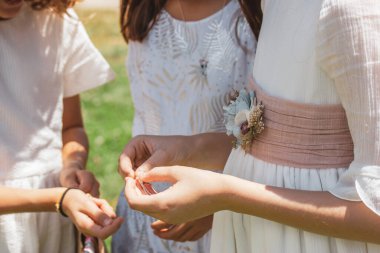 Üç küçük kız. Nedimeler. Klasik beyaz elbiseli, kurdeleli, çiçekli. Kız arkadaşlar sırlarını paylaşırlar. Kızlık, şefkat, çocukluk. Bir çocuk, arkadaşlar ellerinde bir şeye bakıyor..