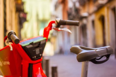 Madrid, İspanya. 1 Temmuz 2022 Lime + Uber 'den kırmızı yeşil bir bisiklet kaldırıma park edildi. Çevre dostu güvenli paylaşım taşımacılığı, şehir ortamında kiralık bisiklet. 