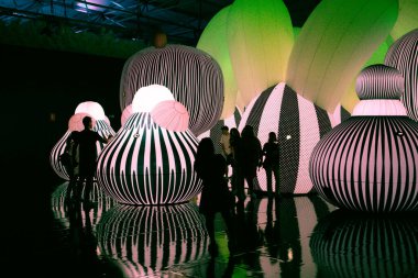 Madrid, İspanya. 6 Temmuz 2023 Pop Air Balon Müzesi Genç Çağdaş Sergisi alışılmadık renkli balon nesneleri ile. Sergideki ziyaretçiler karanlıkta. Rakamlarla ışık gösterisi. Işıklı gösteri.