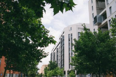 Madrid, İspanya. 5 Haziran 2023, güneşli bir günde modern mimarisi olan bir yerleşim yeri. Birçok apartmanı olan yüksek binalar. Modern tarzda beyaz sarayların ön cephesi İspanya Emlak
