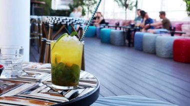 Alkol sarısı yeşil mojito kokteylleri, limonlu limonlu bardaklar masada sulu taze bir içecek, kafede içki, yaz mevsiminde restoran terasında servis edilen. Yaz tatili, eğlence, eğlence, eğlence