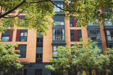 Modern mimarisi olan bir yerleşim yeri. Birçok apartmanı, penceresi ve balkonu olan yüksek binalar ön cephe manzaralı. Madrid 'de yeşil yapraklı bir ev. İspanya' da kiralık ev.