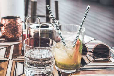 Bir kafede, bir mozaik masasında karbonatlı meşrubat. Cin tonik kokteyli ya da restoran terasında içki bardağında aperol spreyi. Taze yaz içecekleri, meyveli su. Kahverengi tonlama fotoğrafı.