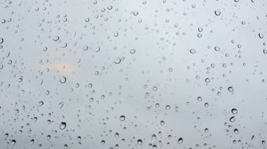 Window with small raindrops on the surface of a glass against a blue cloudy sky after a storm. Weather forecast. Rainy season. Fall or spring cold day. View of the sky from the window. Air concept. 