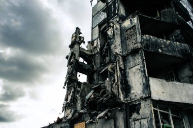Ön cephede yıkılmış bina yangından sonra yıkıldı, tuğla duvarlar. Savaştan sonra mahvoldu. İsrail, Suriye, İran, Ukrayna 'da savaş kavramı. Soyut bina dramatik gri gökyüzüne karşı bombalarla tahrip edildi.
