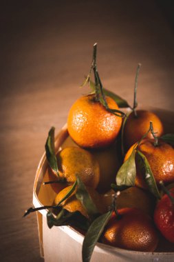 Ekolojik sepet, paketleme, olgun sulu portakal portakallarıyla dolu kutu ahşap bir mutfak masasında. Turunçgil meyvesi topluyorum. Taze meyve ve C vitamini yaz hasadı. Gıda blogu yaşam tarzı.