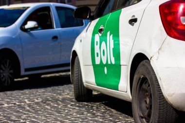 Kyiv, Ukrayna. 3 Mayıs 2021. Yeşil Bolt taksi logosuna sahip beyaz sedan araba asfalt bir caddede ilerliyor. Tallinn, Estonya 'dan popüler bir ulaşım ağı şirketi. Çevrimiçi taksi.