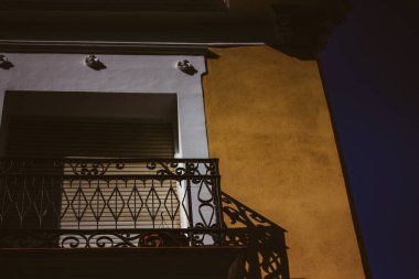 Madrid, İspanya 1 Temmuz 2023. Güneşli bir günde zıt gölgelerle kaplı balkonlu eski bir evin köşesi. Bir apartmanın ön cephesi. Sarı bina köşesi. Tarihi köy, kasaba, şehir