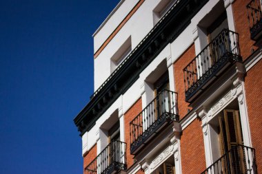 Madrid, İspanya. 7 Ağustos 2023. Kırmızı ve beyaz tuğlalı binanın köşesi. Yazın şehir merkezinde tarihi bir ev. Süslü, güzel bir dış görünüş. Kentsel alandaki yerleşim alanı. 