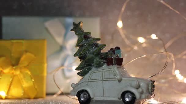 玩具白色复古车与圣诞树 礼品盒在屋顶上 2024年新年 圣诞节的概念 买礼物 冬季购物 在银光闪闪的节日背景下献上花环黄灯 — 图库视频影像