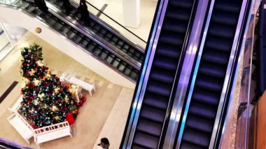 Kyiv, Ukrayna 1 Aralık 2021 İnsanlar modern alışveriş merkezinde yürüyen merdivenlere biniyor. Bir mağazanın içi yılbaşı ağacı ile süslenir. Şehir halkı yaşam tarzı. Kış tatili.