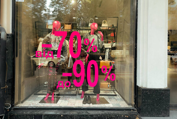 Kyiv, Ukraine October 2, 2023 Shop window of women's clothing store with pink discounts from -70 to -90. Black Friday sales in glamour female boutique. Window display in shopping mall. 