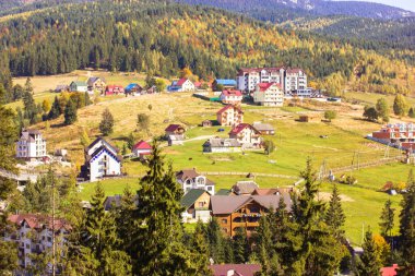 Bukovel, Ukrayna, 7 Ekim 2021. Kır evi manzaralı yeşil çatı katları, havadan çekilmiş bir fotoğraf. Sonbaharda, yazda, baharda, çam ormanlarında bir dağ evi. Eko köyü, kırsal bölge.